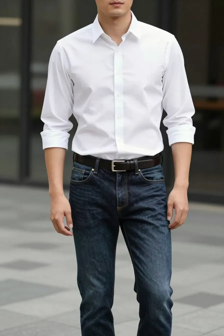 Stylish model wearing pristine white button-down shirt with dark wash slim jeans, casual rolled sleeves, slim leather be