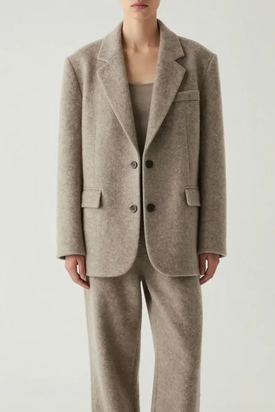 Model wearing oversized soft wool blend blazer in neutral tone, paired with relaxed cropped trousers, contemporary styli